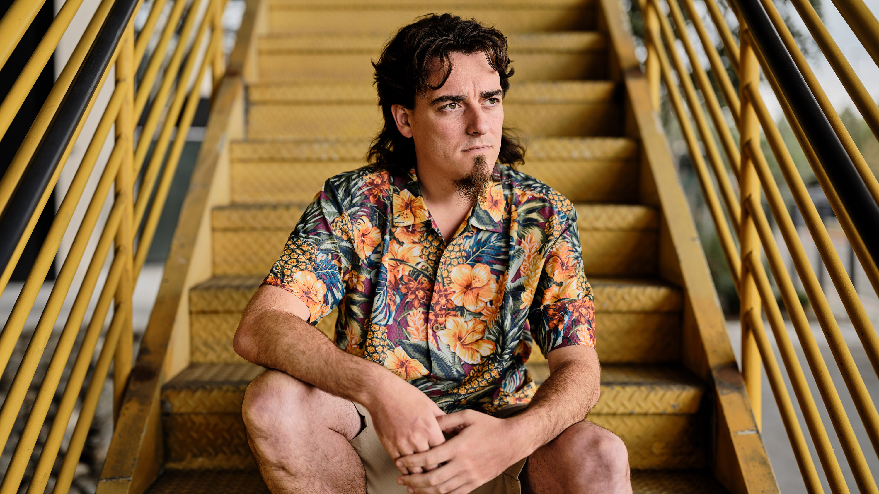 Palmer Luckey sitting on yellow metal staircase