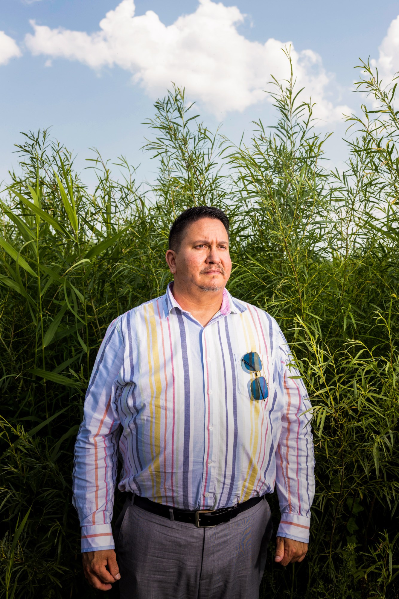 Kelly Applegate standing by the tall grasses of the lake shore