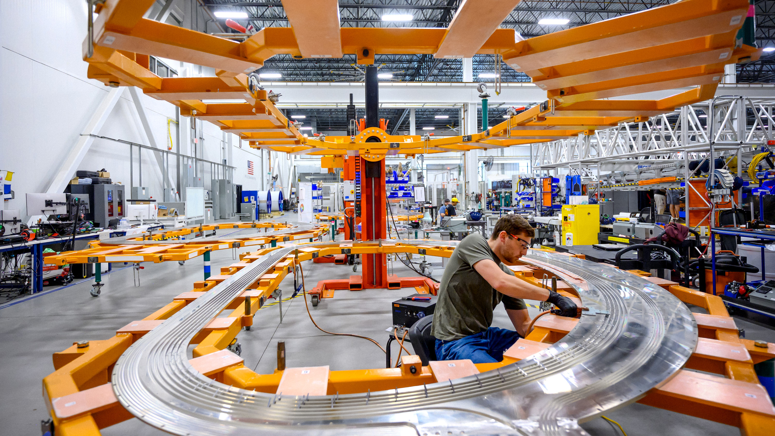 worker at the magnet factory working inside a metal ring