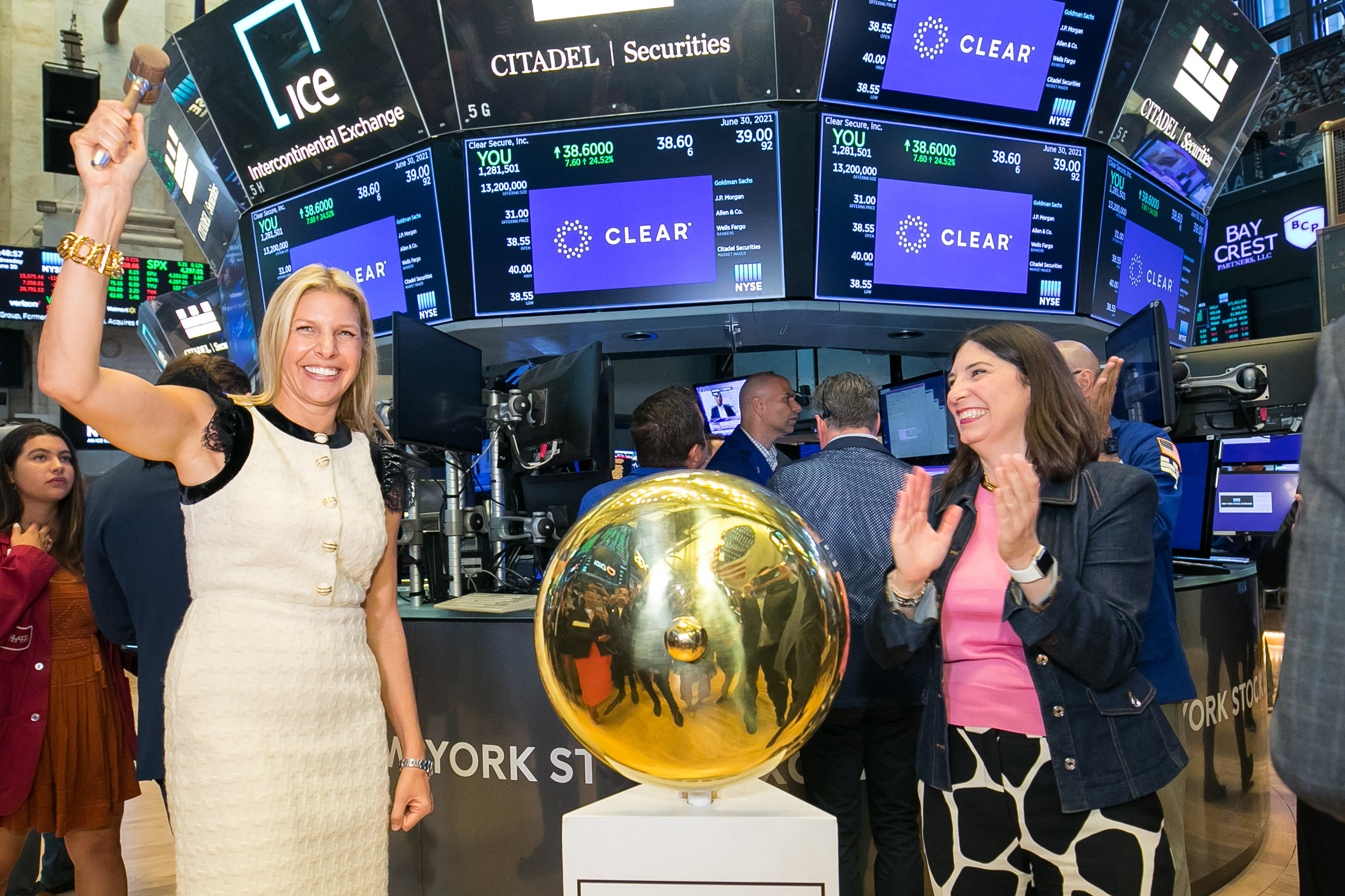 Seidman-Becker with the gavel raised above her head next to the opening bell on the floor of the stock exchange with NYSE Group president Stacey Cunningham clapping on the right side of the frame